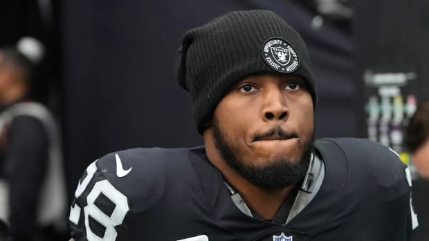 Raiders running back Josh Jacobs (28) warms up before a game against the Patriots at Allegiant Stadium.